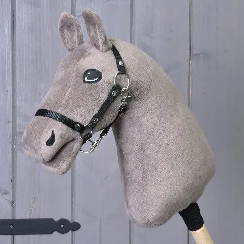 The "Build your horse" hobby horse by related_to_12441055625556 features a taupe head with a black and white mane and bridle, mounted on a wooden stick, displayed before gray wood panels.