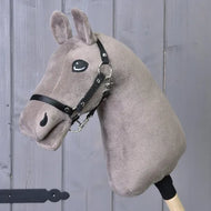 The "Build your horse" hobby horse by related_to_12441055625556 features a taupe head with a black and white mane and bridle, mounted on a wooden stick, displayed before gray wood panels.