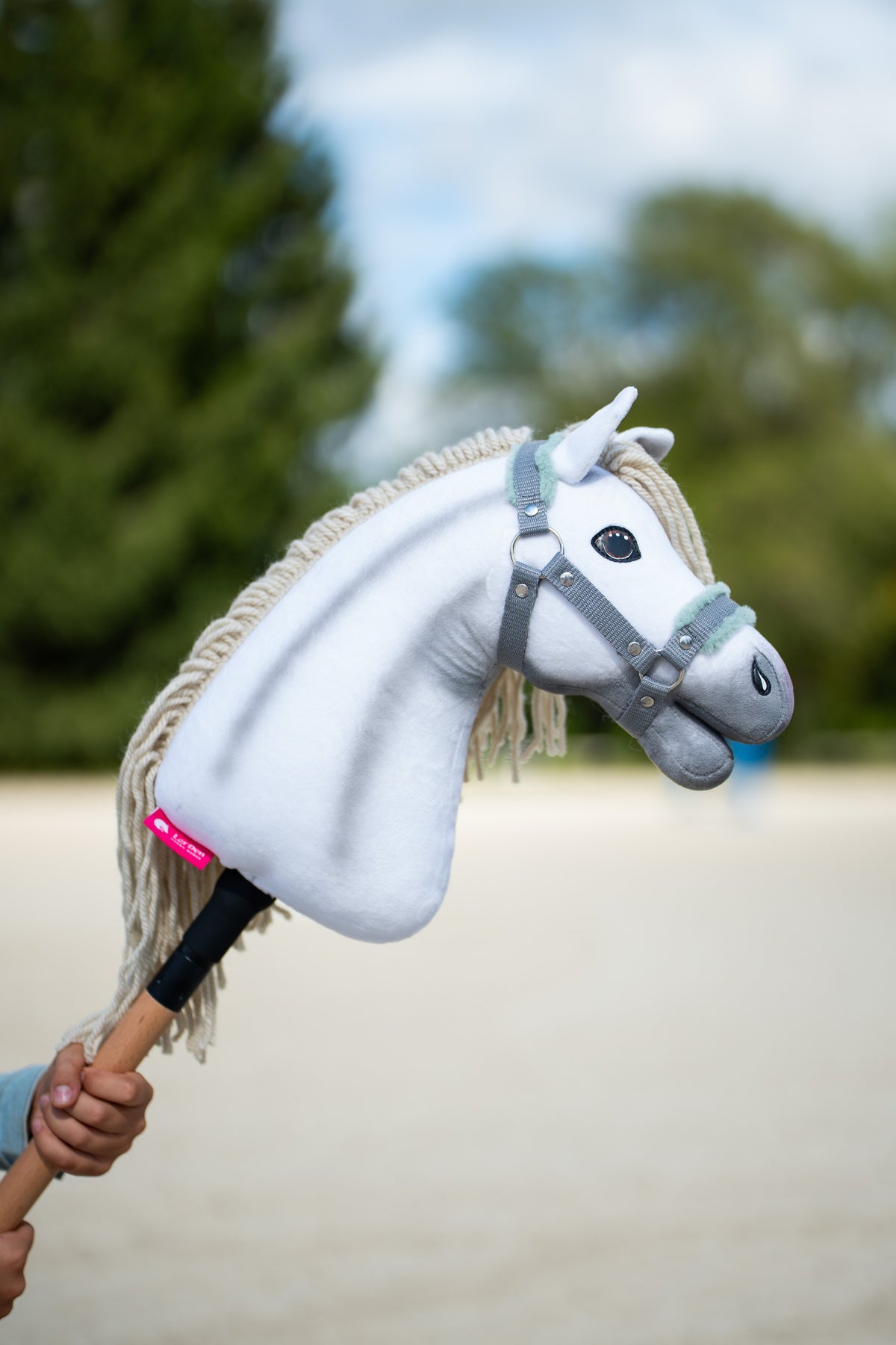 Hobby Horse Little Lady s čiernou ohlávkou vonku s bielou plyšovou hlavou a krémovou priadzovou hrivou