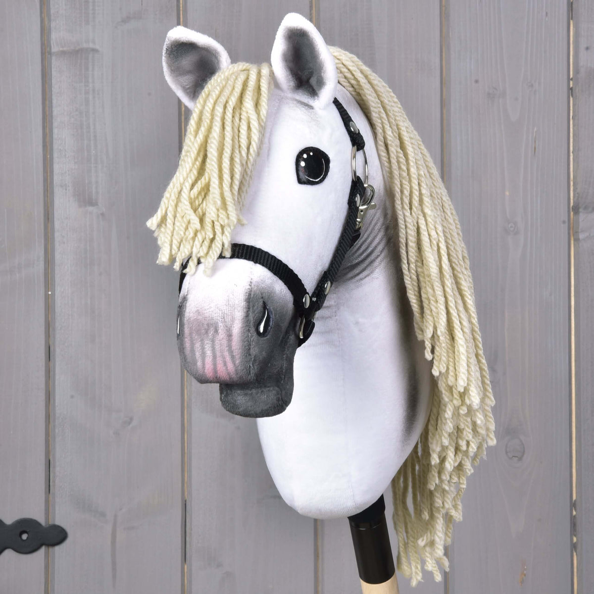 Hobby Horse Little Lady s čiernou ohlávkou od Hobby Horse LarDen má čiernu ohlávku, veľké čierne oči a dlhú svetlo blond hrivu z priadze na tyči – ideálny pre nápaditú drezúrnu hru na pozadí svetlého dreva.