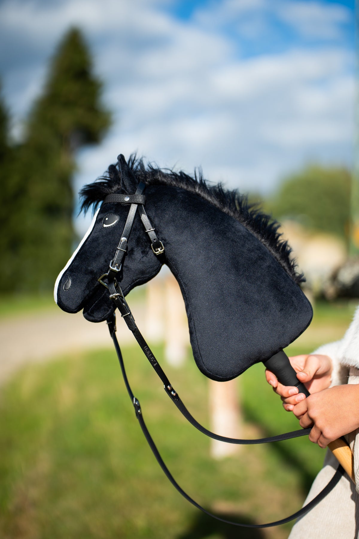 Čierny Hobby Horse s čiernou uzdečkou z koženky a oťažami vonku