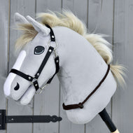 Nákrčník Chocolate od Hobby Horse LarDen so sivým plyšovým Hobby Horse, čiernou uzdečkou a krémovou povrazovou hrivou na drevenej tyči, na pozadí sivého dreveného panelu.