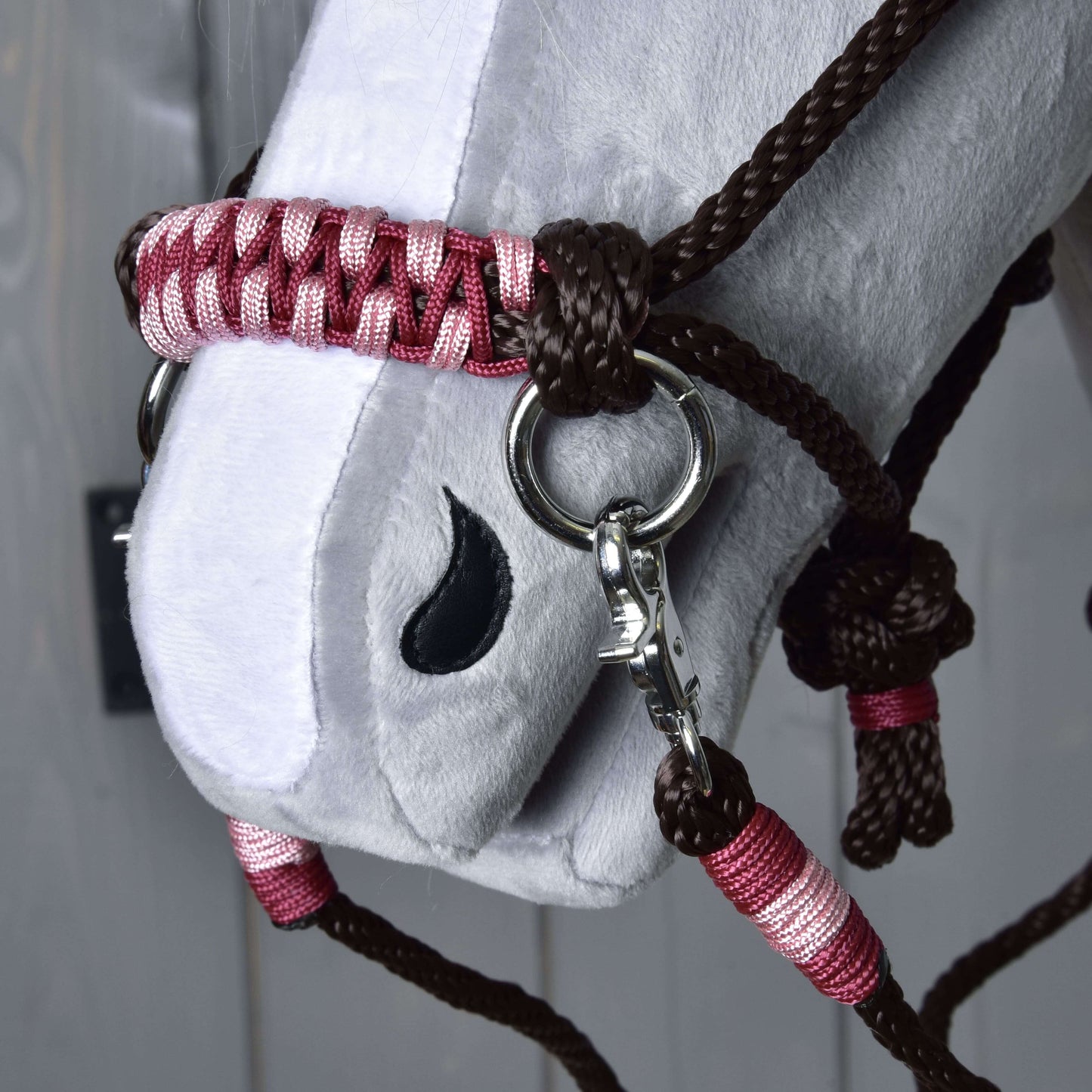 Detail bielej plyšovej hlavy Hobby Horse LarDen so setom Rope set York — hnedou a ružovou pletenou ohlávkou s kovovými krúžkami — a čiernym vyšitým detailom nozdry.