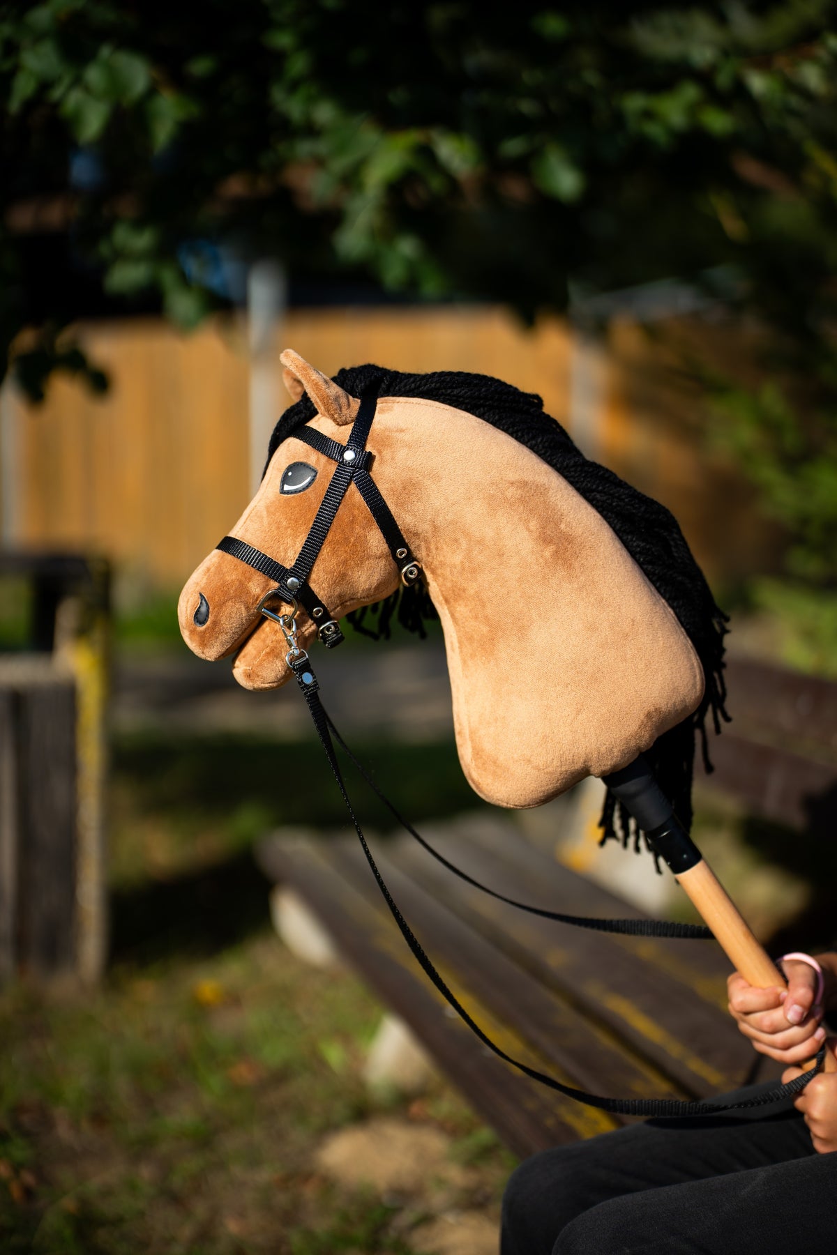 Hlava a krk Hobby Horse Samantha with Black Halter od LarDen zdvihnuté v teplom večernom svetle – pieskový plyš a čierna priadzová hriva – s čiernou uzdečkou s remienkovými oťažami