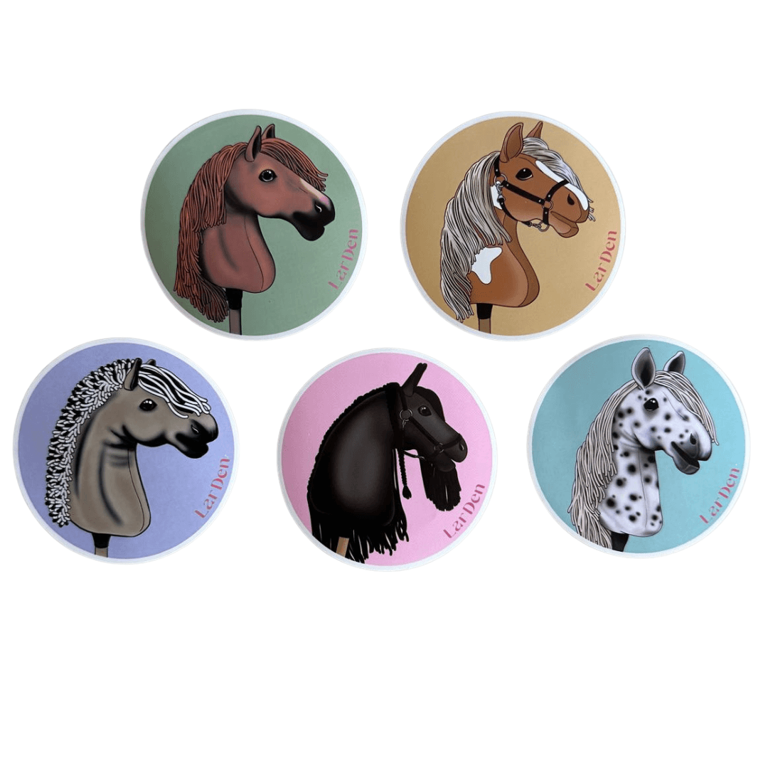 Set Stickers 5 od Hobby Horse LarDen obsahuje päť okrúhlych ilustrovaných samolepiek, každú s jedinečnou hlavou Hobby Horse na farebnom pozadí – zelenom, béžovom, levanduľovom, modrom a ružovom – a so slovom Lelban.