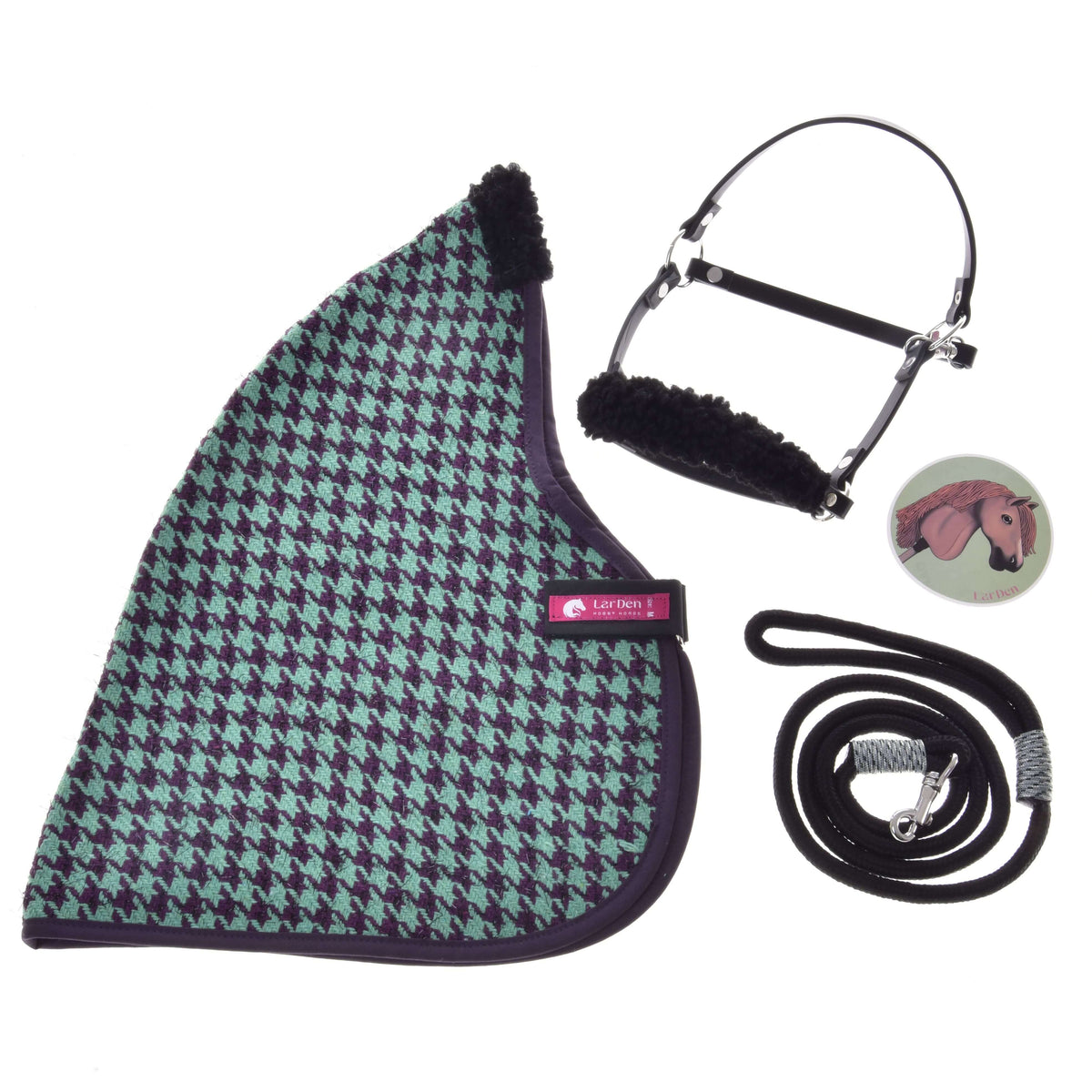 Set Harmony Green od Hobby Horse LarDen rozložený naplocho: zeleno-čierna stajňová deka so vzorom kohútej stopy, čierna ohlávka s fleecovým polstrovaním, čierne vodidlo so striebornou karabínou a okrúhly odznak s ilustráciou koňa.