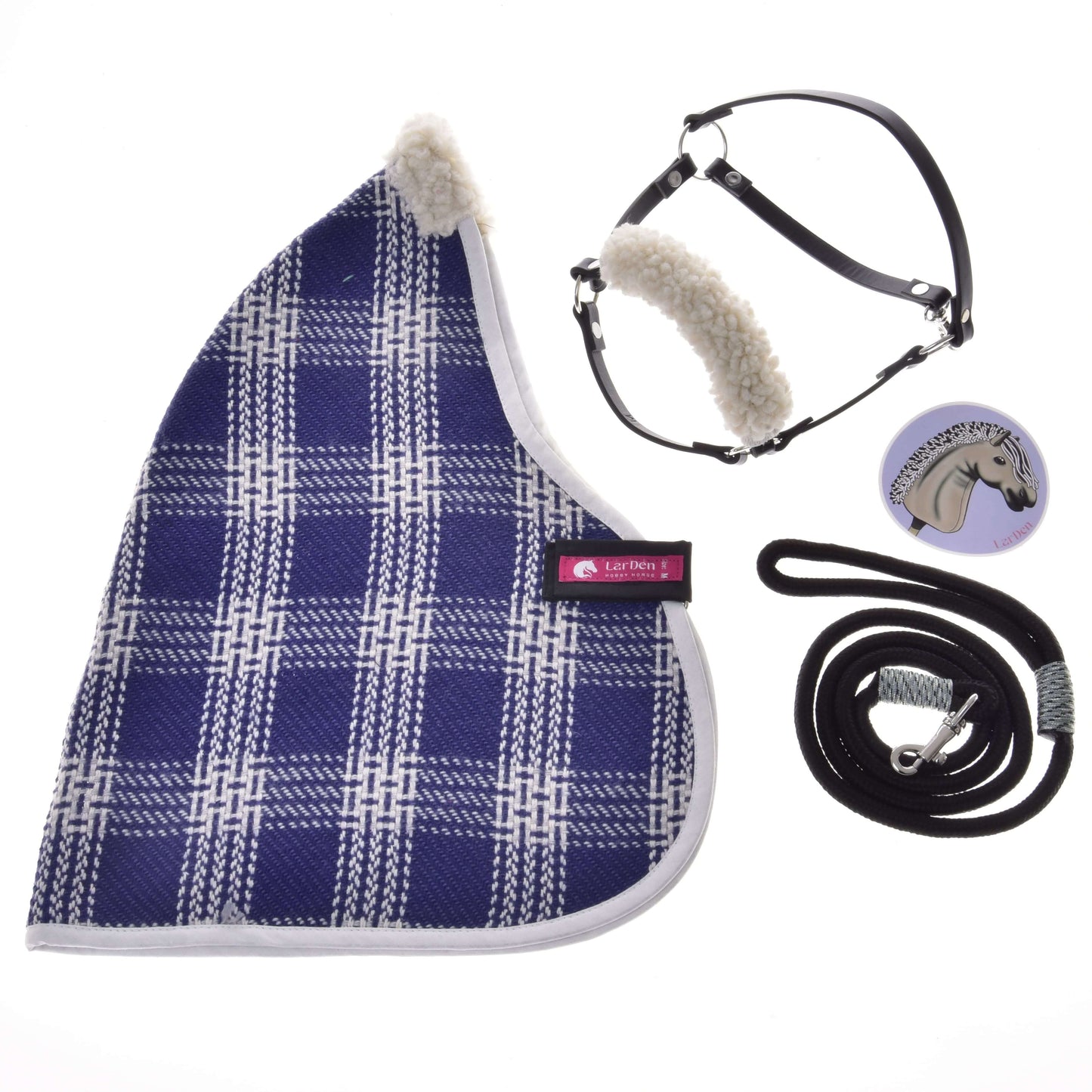 Set Harmony Victory od Hobby Horse LarDen obsahuje modrou kostkovanou stájovou deku, černou ohlávku s bílým fleecem, stočené černé vodítko s kovovou karabinou a kulatý odznak s koňskou hlavou na bílém pozadí.