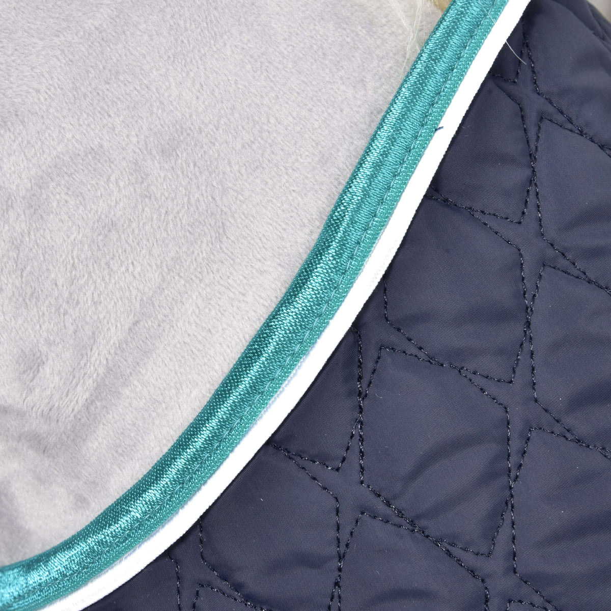Detail deky Set Supreme Turquoise od Hobby Horse LarDen s prešívanou tmavomodrou látkou s geometrickým prešitím, tyrkysovým lemom a bielou paspulkou – ideálny na ochranu tvojho koňa.