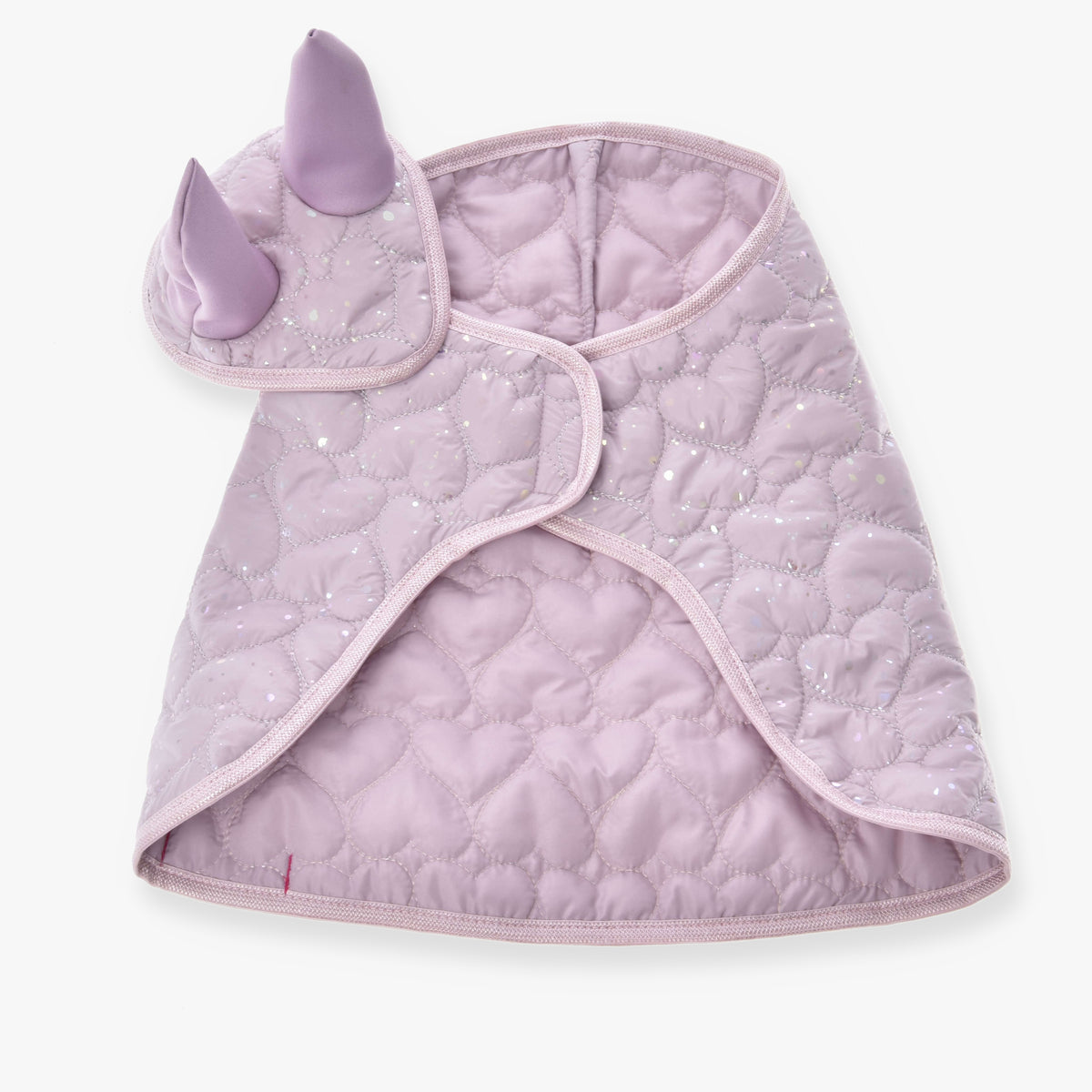 Set Sweetest Heart od Hobby Horse LarDen je prešívaná svetlofialová pelerína pre maznáčikov s dvoma levanduľovými rohmi a textúrou so vzorom sŕdc s jemným trblietaním, pripomínajúca rozmarnú deku pre Hobby Horse, zobrazená naplocho na bielom pozadí.
