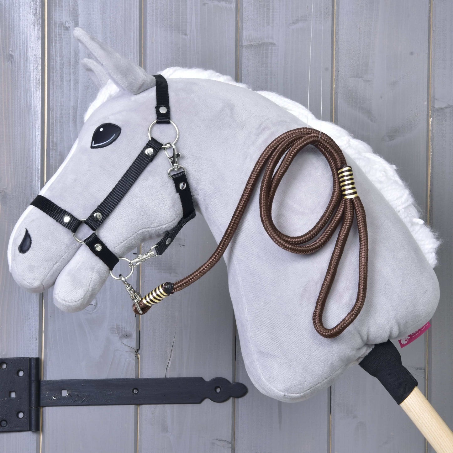 Hobby Horse - vodidlo Vivaldi od Hobby Horse LarDen zavesené na drevenom nástennom držiaku na pozadí sivého dreva.