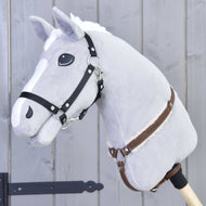Poprsník s barančekom Walnut od Hobby Horse LarDen na plyšovom sivom Hobby Horse s bielou hrivou, čiernou uzdečkou, koženými oprátami a drevenou tyčou, na sivom drevenom pozadí.