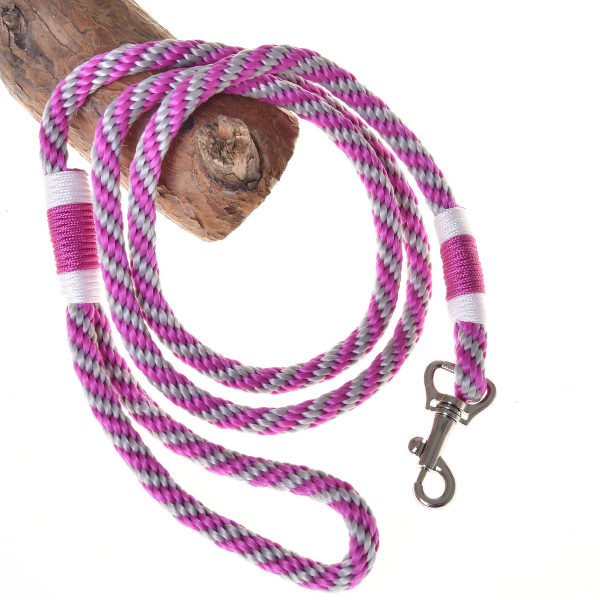 Hobby Horse - vodidlo ružový prúžok od Hobby Horse LarDen s ružovým, bielym, fialovým a čiernym pletením a kovovou karabínou, stočené na dreve na bielom pozadí.