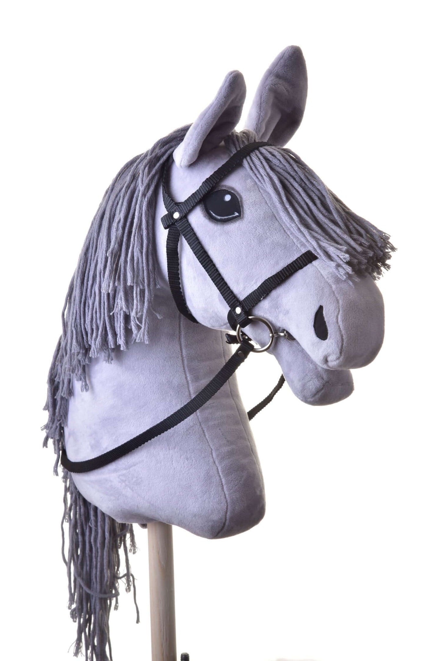 Čierna uzdečka s oprátami z popruhu od Hobby Horse LarDen na sivom plyšovom Hobby Horse s dlhou priadzovou hrivou, nasadenom na drevenej tyči a odfotografovanom na bielom pozadí.